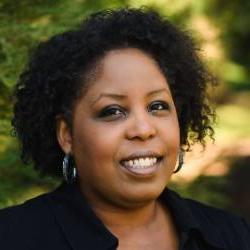 a headshot of an artist with short curly hair